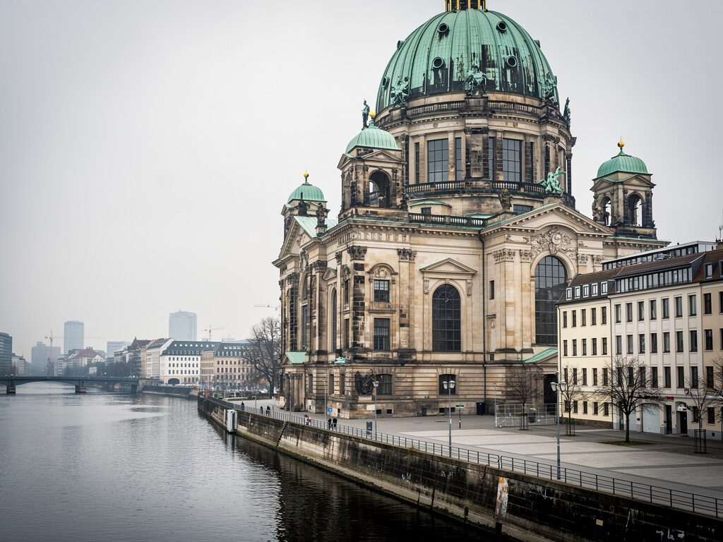 Großer evangelischer Dom mit grüner Kuppel am Fluss in der Hauptstadt