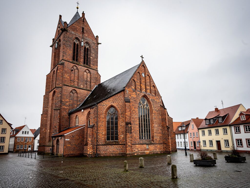 Rote Backstein-Marktkirche mit massivem Turm in einer niedersächsischen Stadt