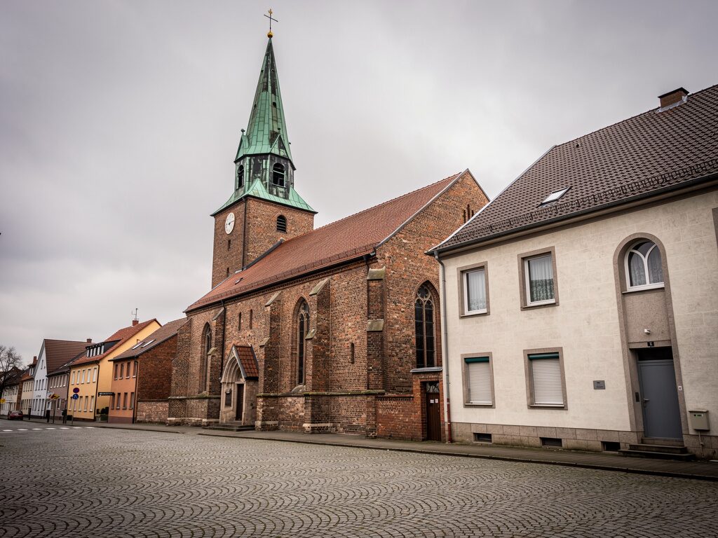 Evangelische Stadtkirche mit grünem Kupferturm in einer westfälischen Stadt